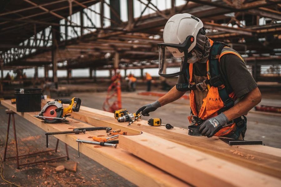 Carpenter cutting lumber with power tools on a job site