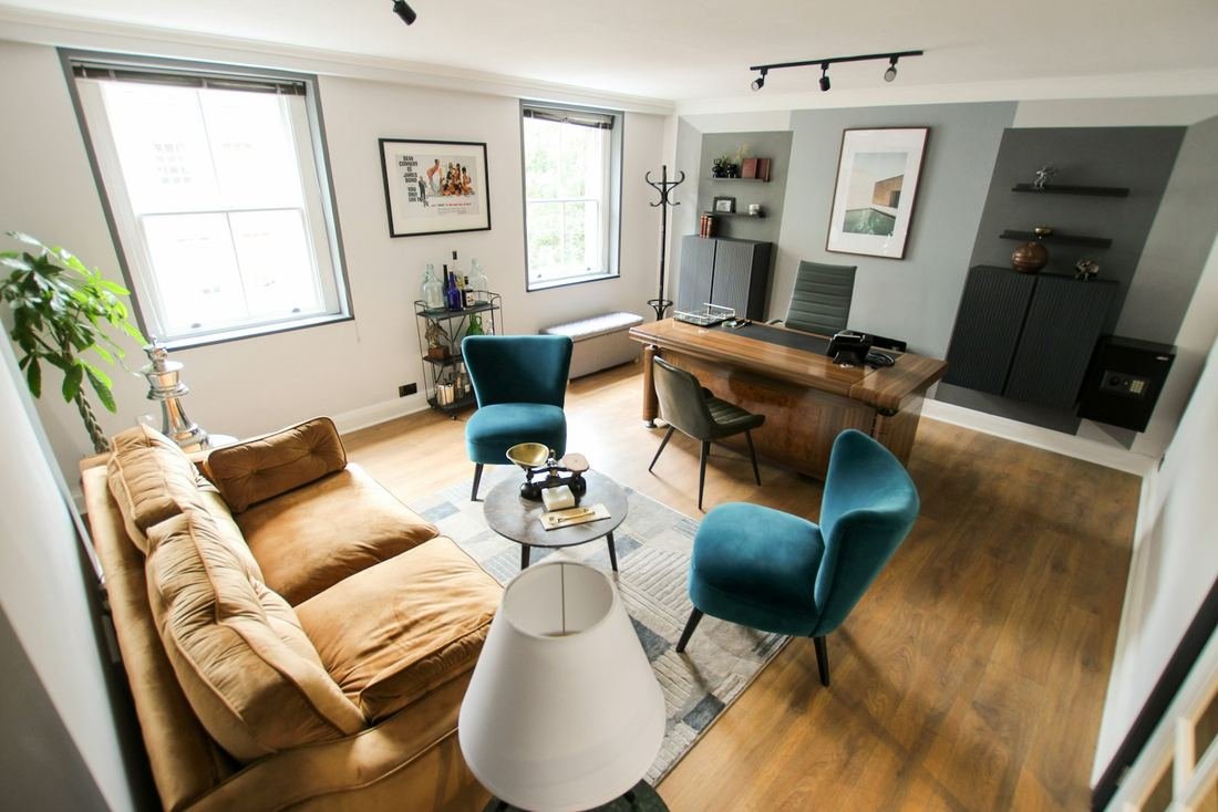Living room with teal chairs and hardwood floors